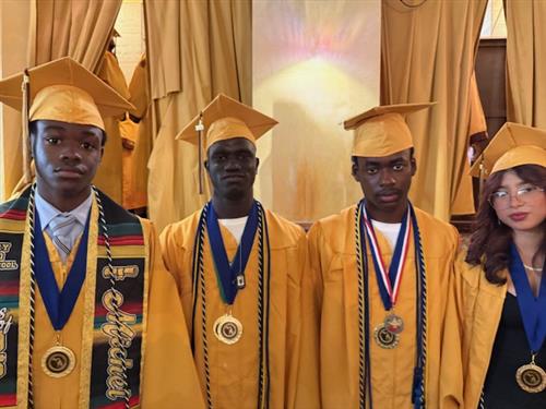students in gold caps and gowns with their medals proudly displayed